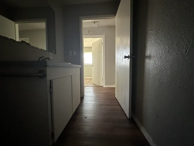 a view of a hallway with wooden floor and staircase