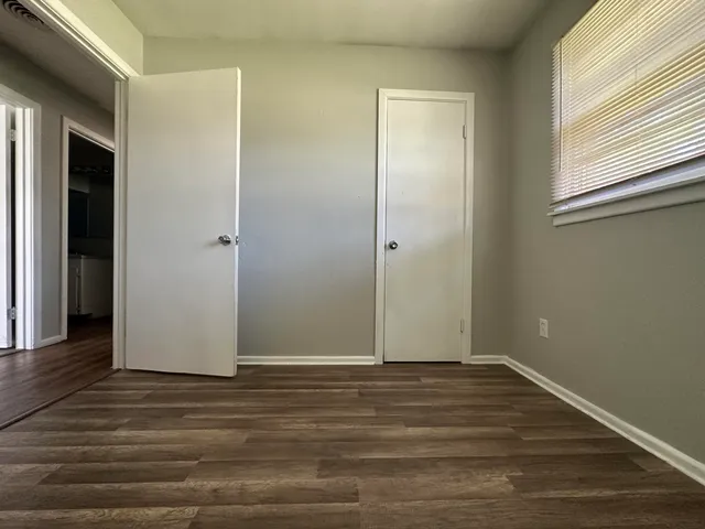 a view of room with window and wooden floor