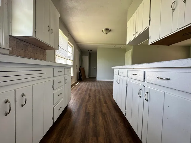a view of a kitchen with cabinets and wooden floor
