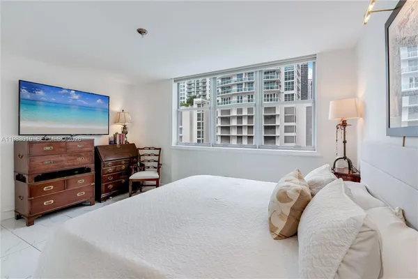 a bedroom with a bed and a flat tv screen