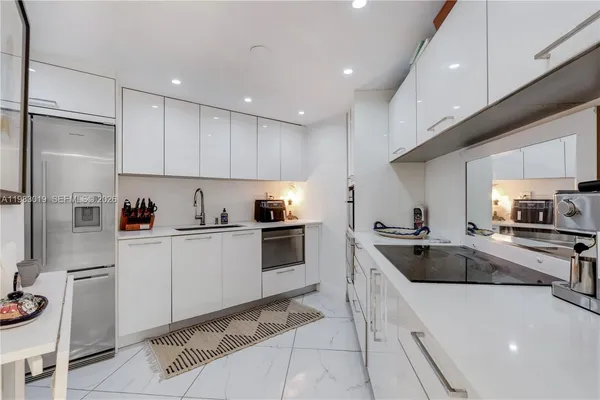 a kitchen with granite countertop a sink stainless steel appliances and cabinets