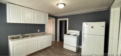 a kitchen with a refrigerator a stove and white cabinets