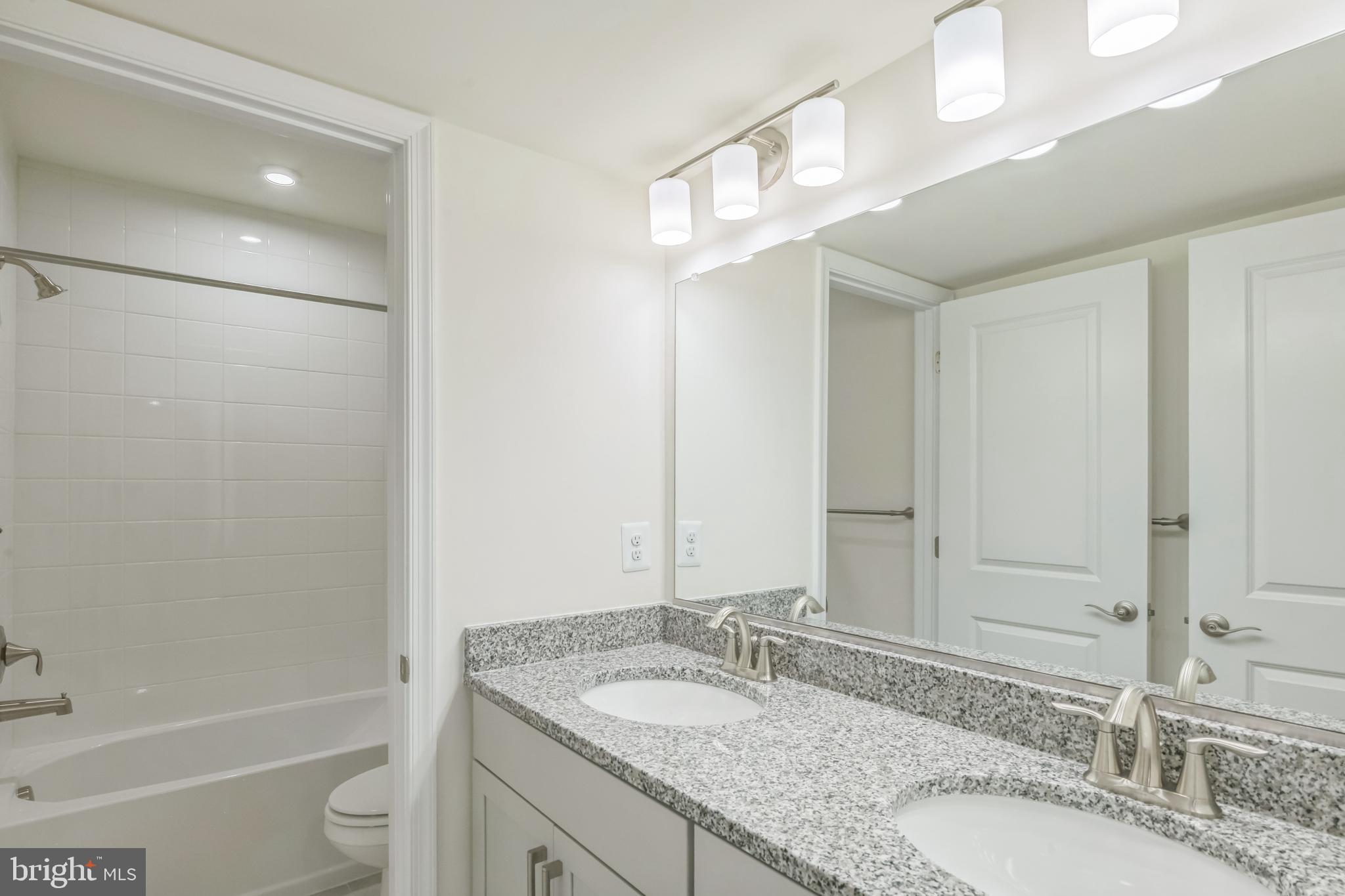 392 Scranton Lane Ocean View, DE 19970 - Photo 13 of 15 a bathroom with a granite countertop sink a mirror and a bathtub