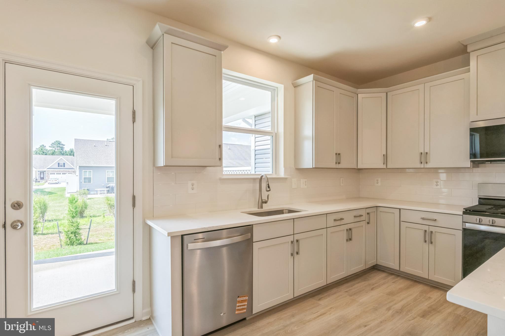 392 Scranton Lane Ocean View, DE 19970 - Photo 7 of 15 a kitchen with a sink white cabinets and white appliances