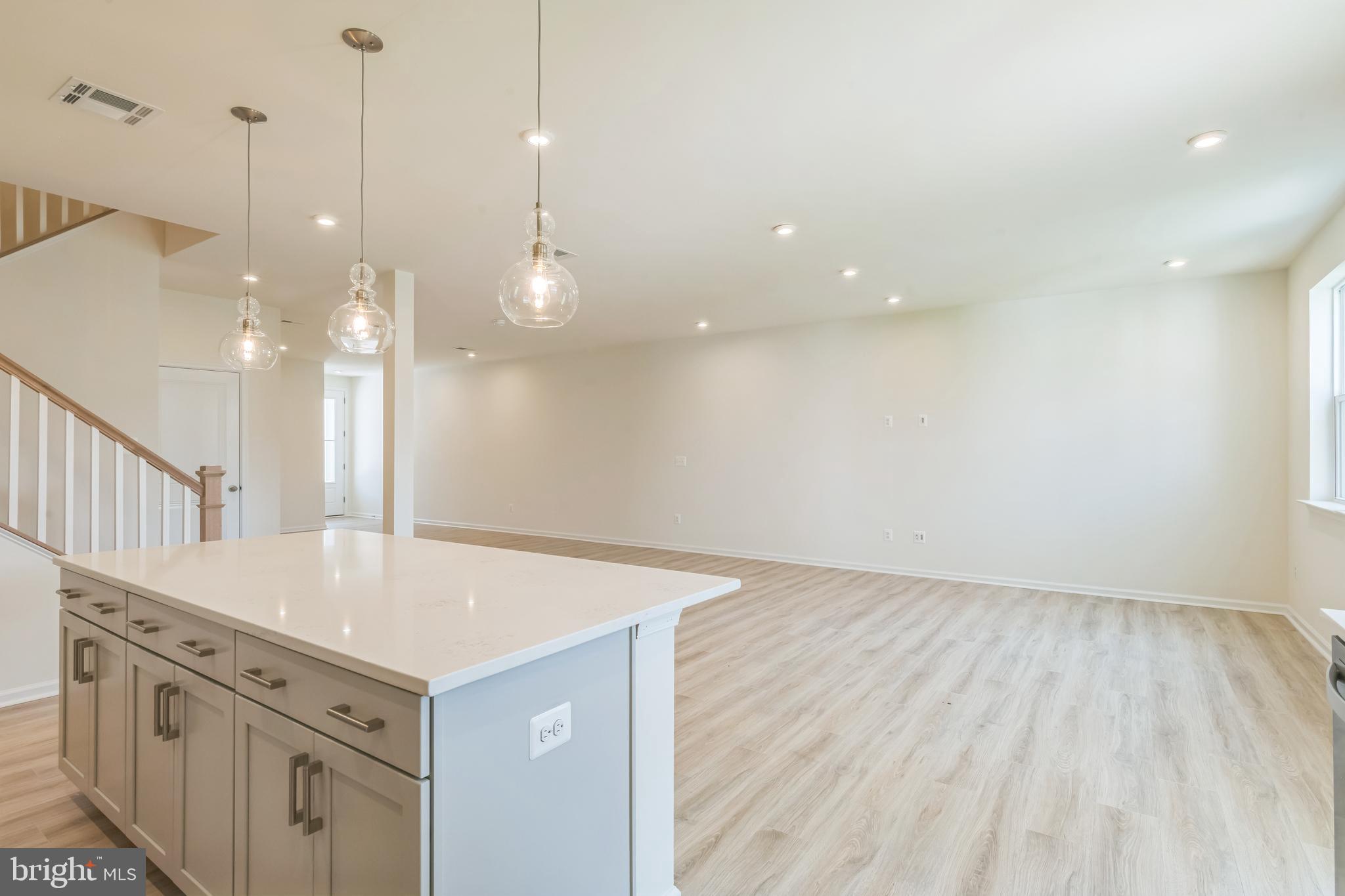392 Scranton Lane Ocean View, DE 19970 - Photo 8 of 15 a view of a kitchen island a sink wooden floor and a ceiling fan