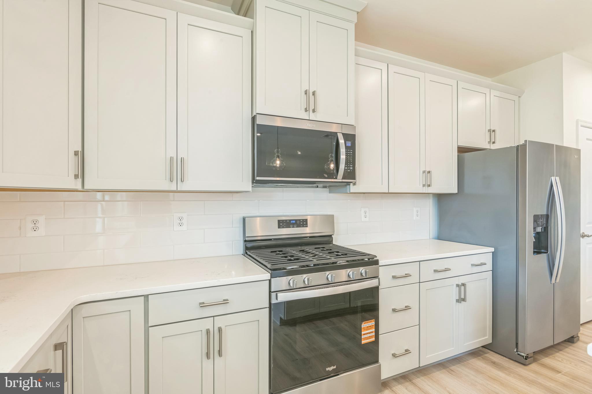 392 Scranton Lane Ocean View, DE 19970 - Photo 9 of 15 a kitchen with stainless steel appliances white cabinets and a stove top oven