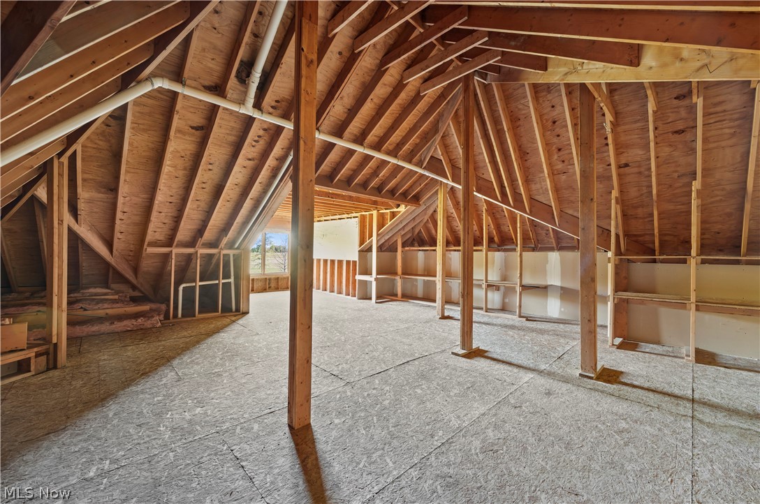 51488 Peck Wadsworth Road Wellington, OH 44090 - Photo 46 of 50 Unfinished attic space featuring exposed wood framing, plywood subflooring, and visible ductwork