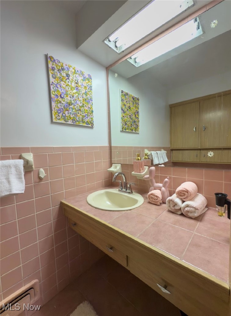 7817 Montello Road Independence, OH 44131 - Photo 21 of 35 Bathroom with a skylight, sink, and tile walls