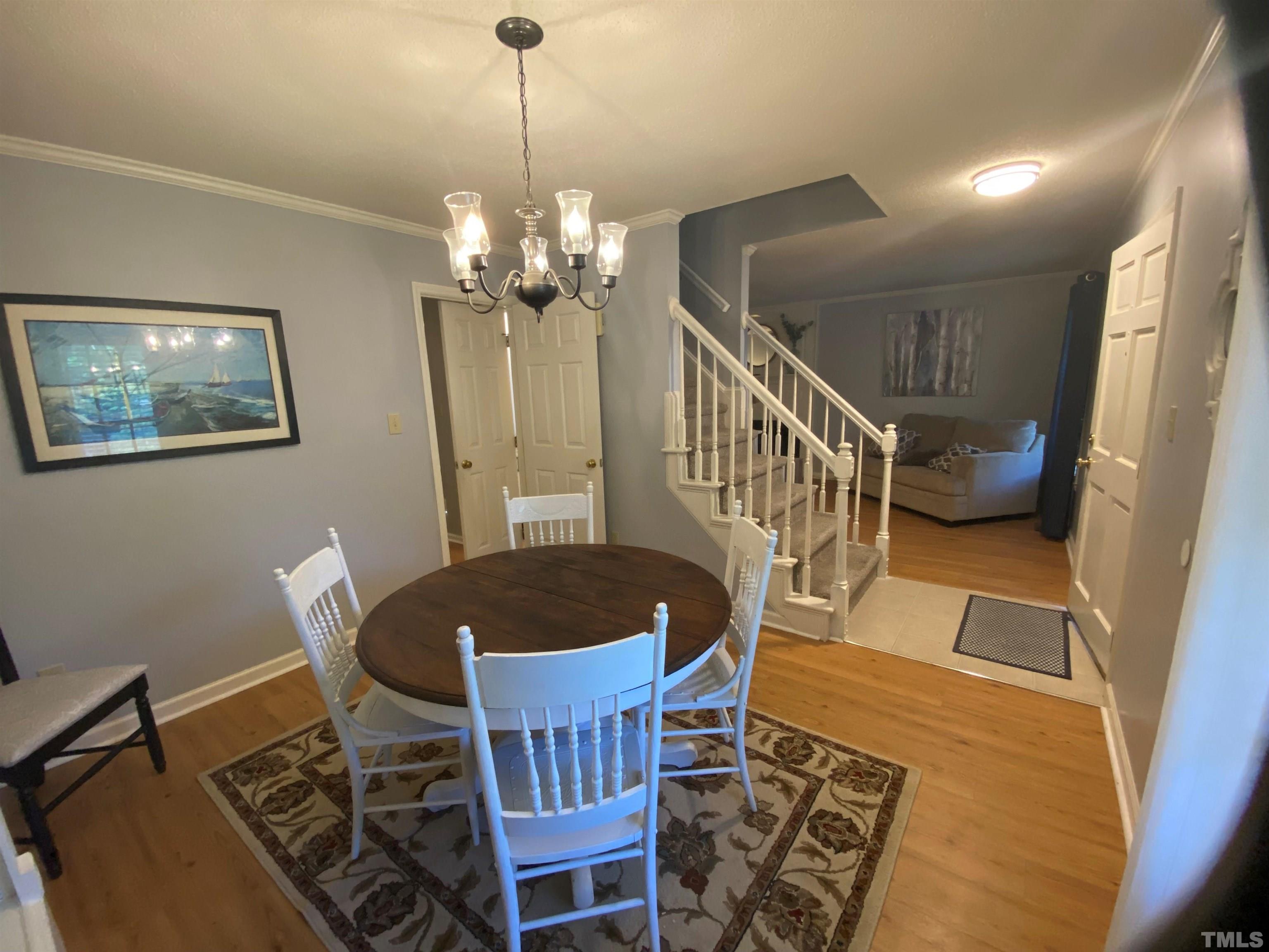 4728 Worchester Place Raleigh, NC 27604 - Photo 6 of 7 a dining room with furniture a rug and a chandelier