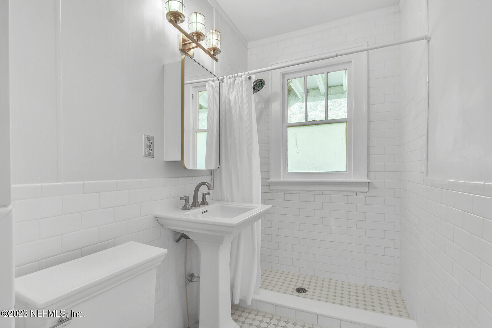3803 Valencia Road Jacksonville, FL 32205 - Photo 18 of 58 a bathroom with a shower a sink and a mirror