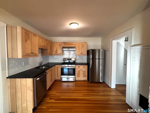 a kitchen with stainless steel appliances granite countertop a refrigerator and a sink