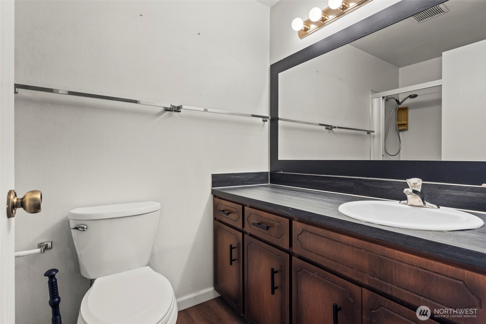 10329 99th Street Southwest Tacoma, WA 98498 - Photo 9 of 25 a bathroom with a sink a toilet and a mirror