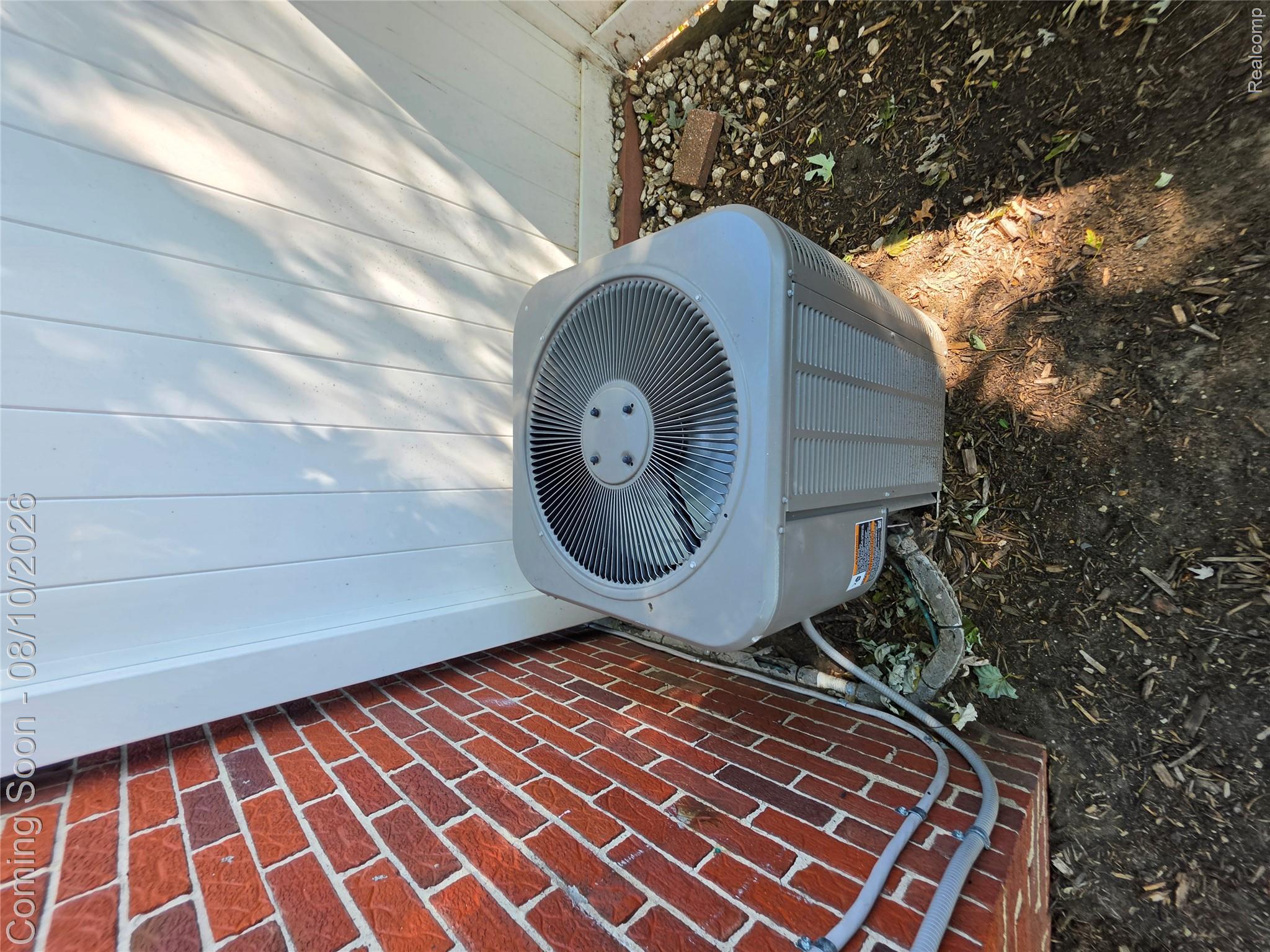 31159 Kelly Road Fraser, MI 48026 - Photo 12 of 13 Efficient HVAC unit positioned in side yard with brick exterior and metal fencing visible