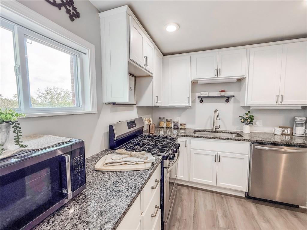 650 Lindsay Road Carnegie, PA 15106 - Photo 6 of 35 a kitchen with stainless steel appliances granite countertop a stove a sink dishwasher and cabinets with wooden floor