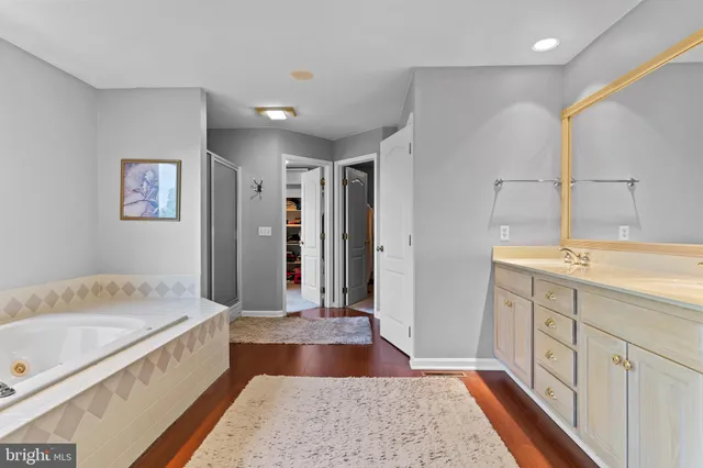 a kitchen with stainless steel appliances granite countertop a stove a sink dishwasher and a dining table with wooden floor