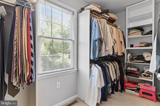 a view of swimming pool with lawn chairs under an umbrella
