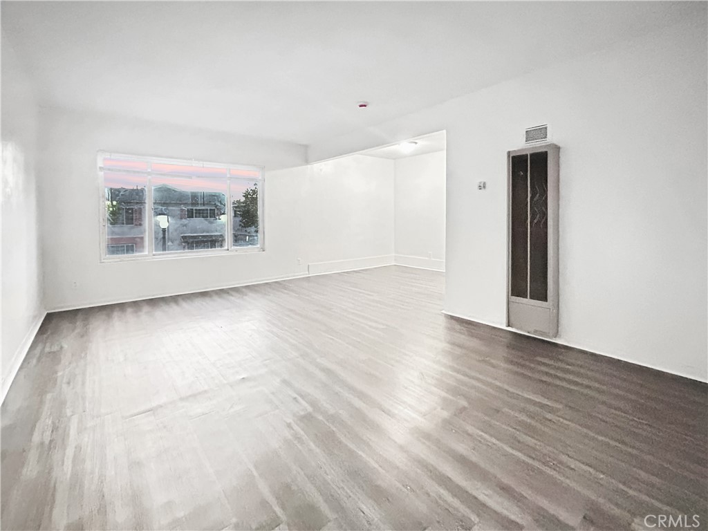 1109 South Minnie Street Santa Ana, CA 92701 - Photo 12 of 20 a view of an empty room with wooden floor and a window