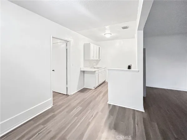 a view of a kitchen with wooden floor and a sink