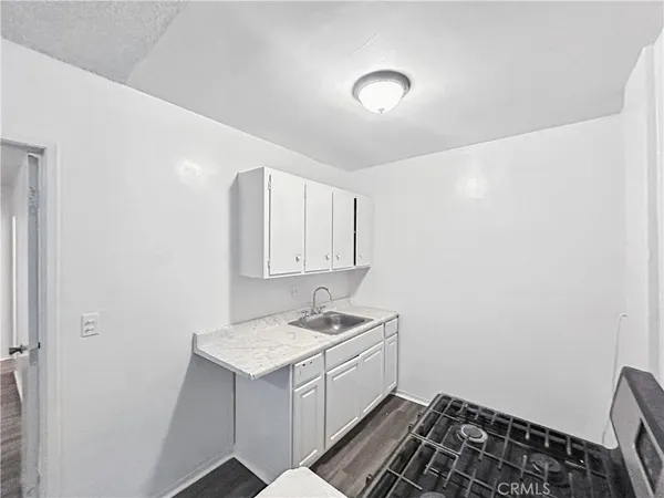 a room with a sink and a stove top oven