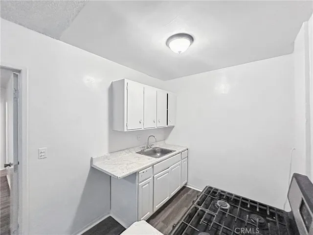 a room with a sink and a stove top oven