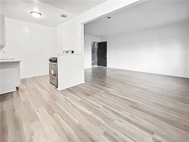 a view of a kitchen with wooden floor and white doors