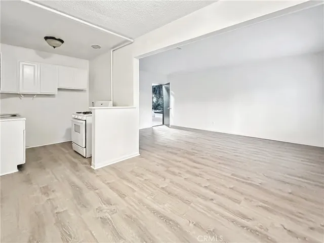 a view of a kitchen with wooden floor and electronic appliances