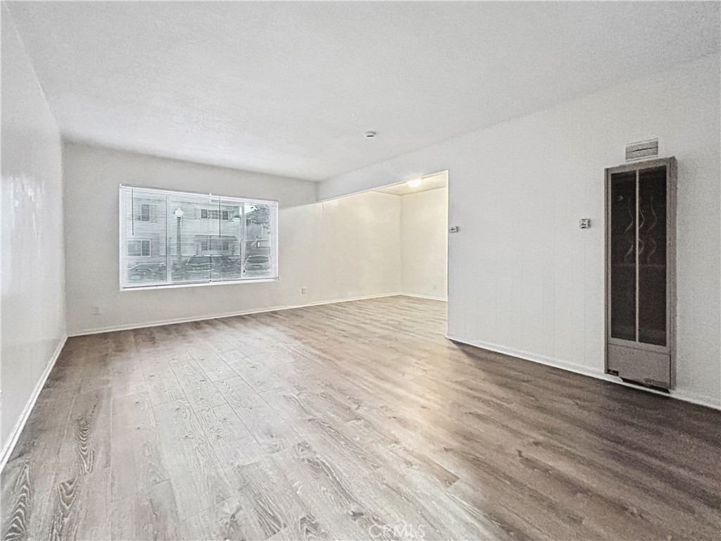 1109 South Minnie Street Santa Ana, CA 92701 - Photo 7 of 20 an empty room with wooden floor and windows