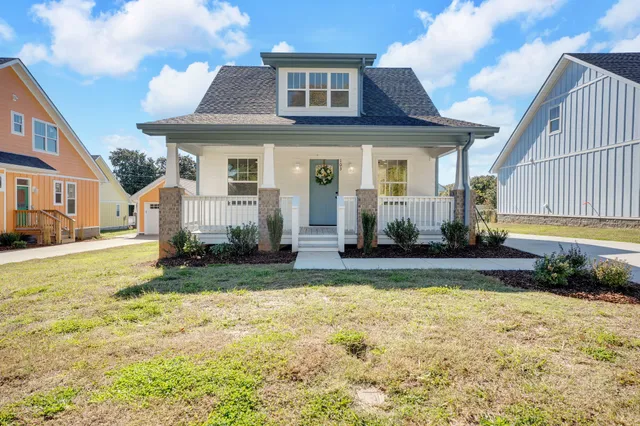 a view of a house with backyard and sitting area