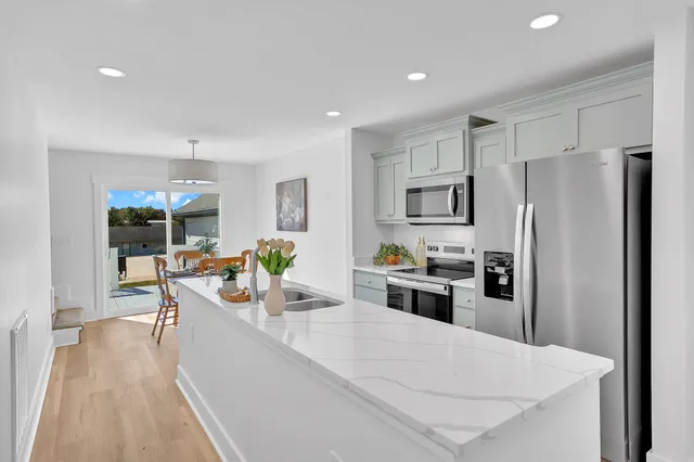 a kitchen with refrigerator and chairs