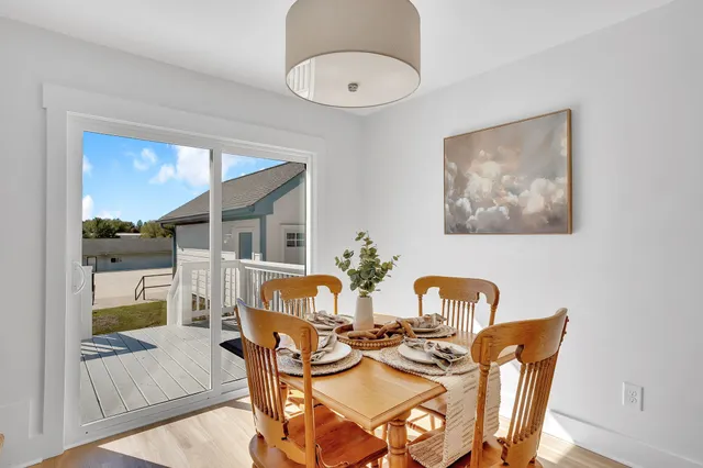 a view of a dining room with furniture a chandelier and wooden floor