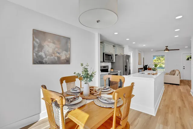 a view of a dining room with furniture wooden floor and a potted plant