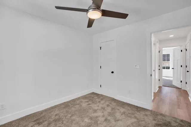 an empty room with a window and a ceiling fan