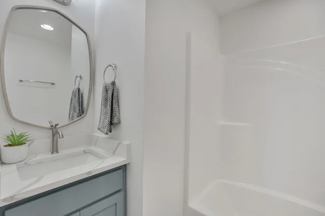 a spacious bedroom with a bed and a wooden floor