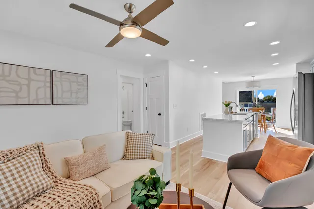 a living room with furniture and a view of kitchen