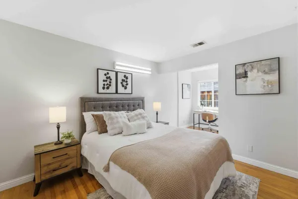 a bedroom with a bed and a lamp on dresser