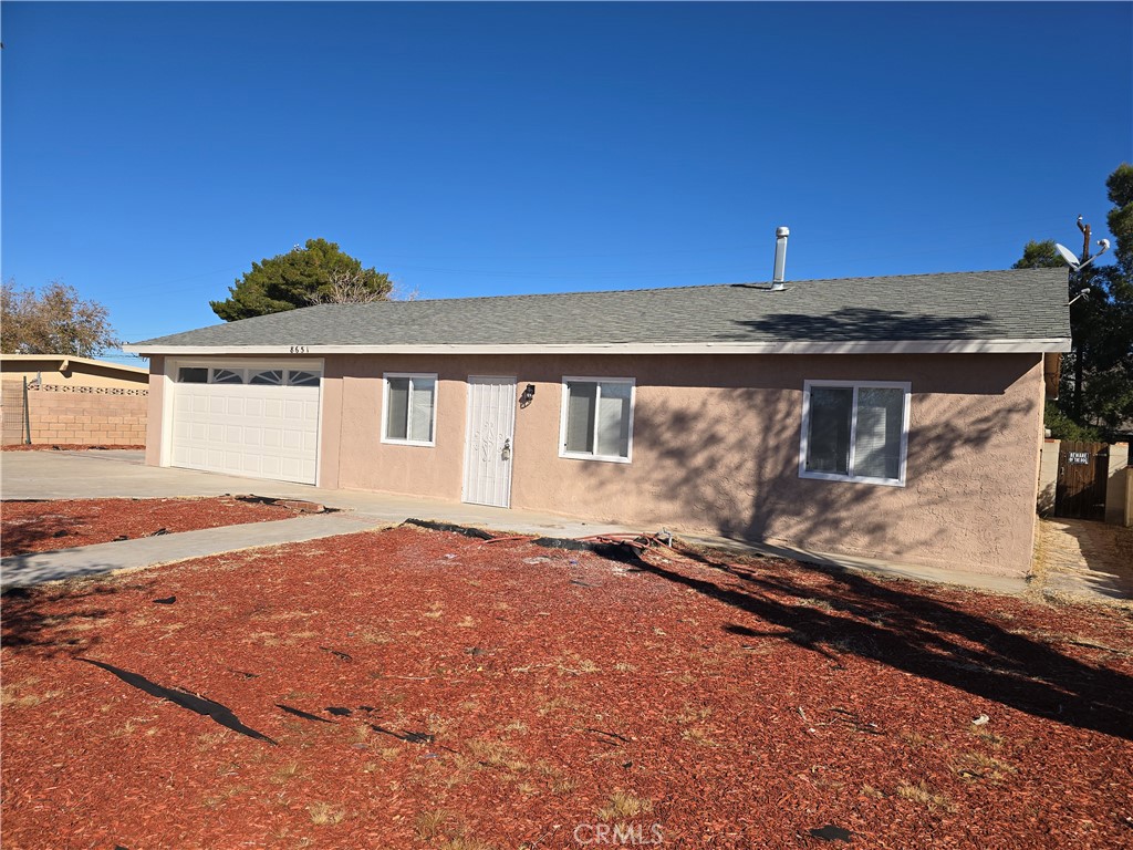 8651 S Loop California City, CA 93505 - Photo 1 of 16 a front view of a house with a yard