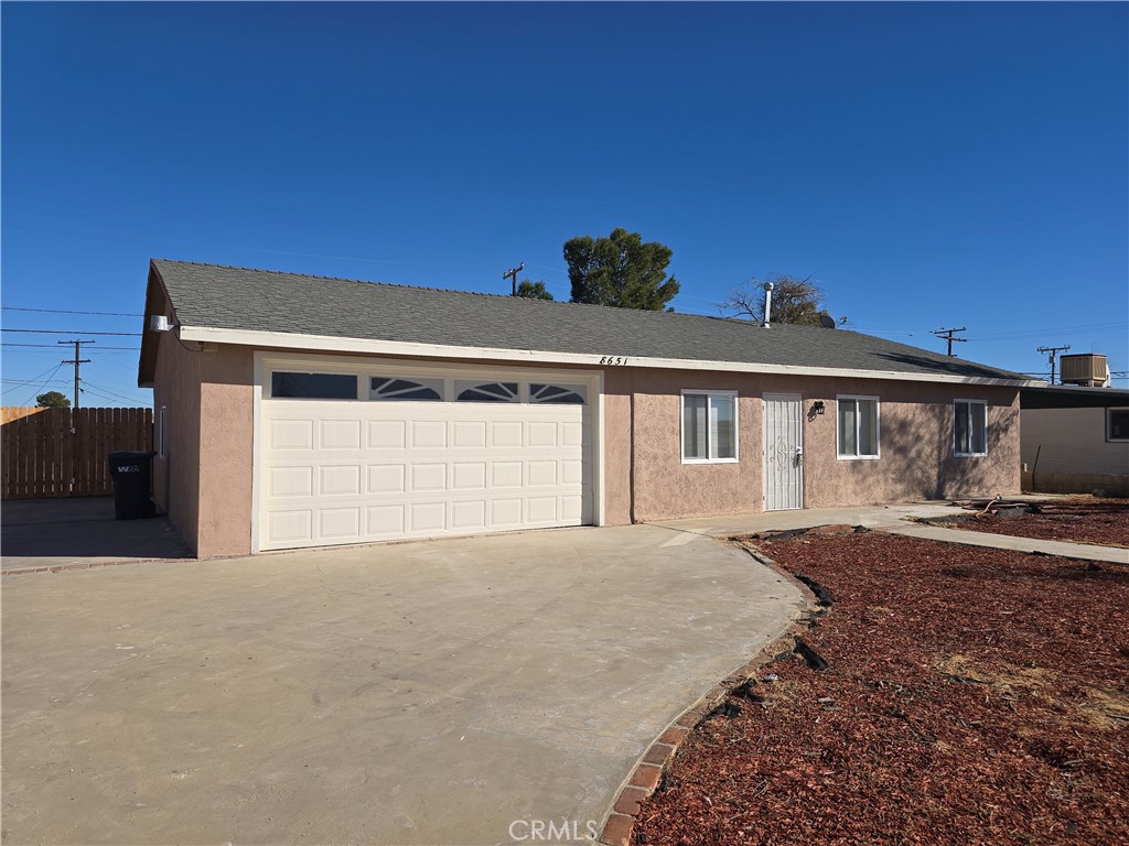8651 S Loop California City, CA 93505 - Photo 3 of 16 a front view of a house with a yard