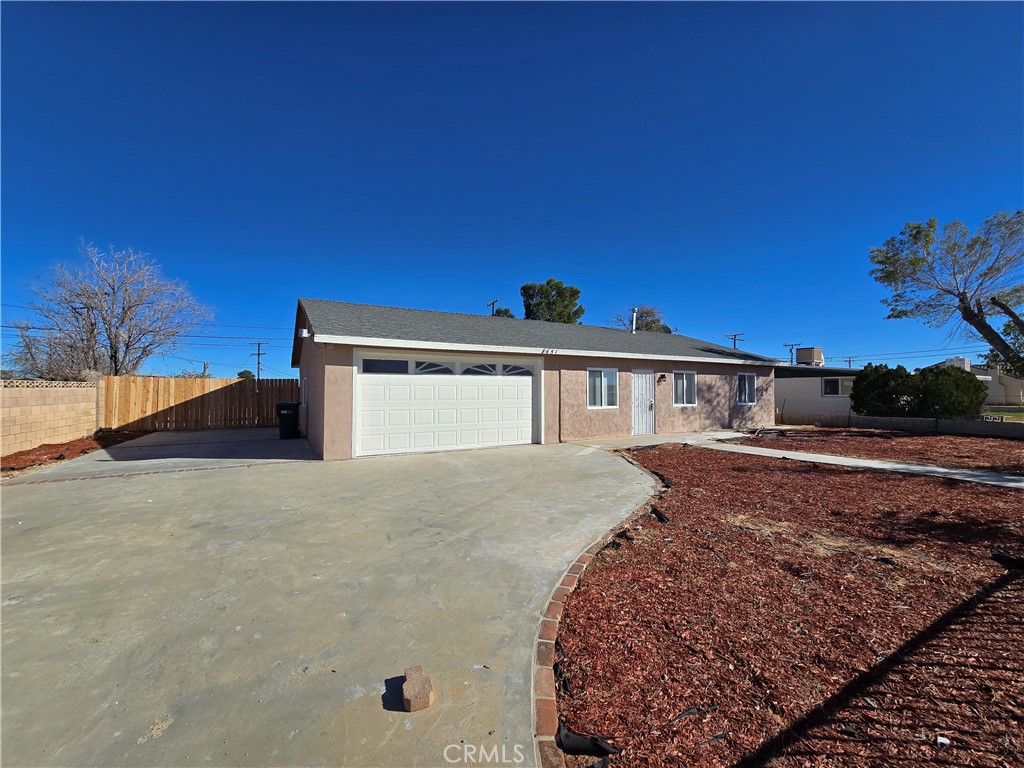 8651 S Loop California City, CA 93505 - Photo 4 of 16 a front view of a house with a yard