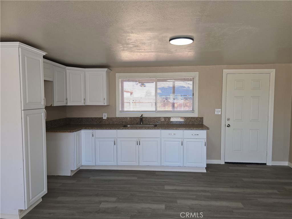 8651 S Loop California City, CA 93505 - Photo 5 of 16 a kitchen with granite countertop white cabinets and a sink