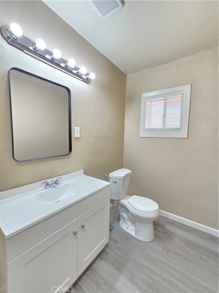8651 S Loop California City, CA 93505 - Photo 10 of 16 a bathroom with a toilet a sink and mirror