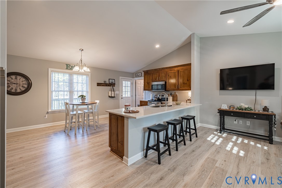 180 Barefords Mill Road Dunnsville, VA 22454 - Photo 11 of 27 a kitchen with stainless steel appliances granite countertop a stove top oven a sink dishwasher a dining table and chairs with wooden floor