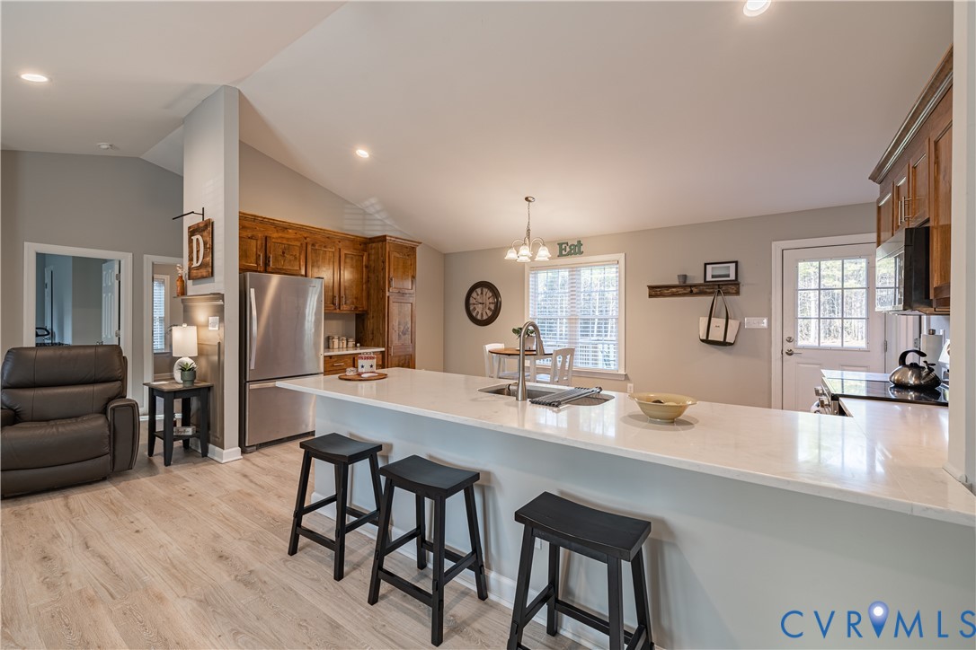 180 Barefords Mill Road Dunnsville, VA 22454 - Photo 12 of 27 a kitchen with kitchen island granite countertop a sink and chairs