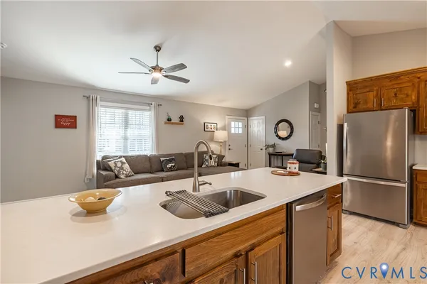 a kitchen with stainless steel appliances granite countertop a sink a refrigerator and a stove