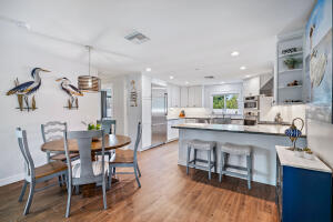 8766 Southeast Longview Drive Hobe Sound, FL 33455 - Photo 13 of 27 a kitchen with kitchen island cabinets and wooden floor