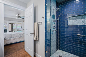 8766 Southeast Longview Drive Hobe Sound, FL 33455 - Photo 15 of 27 a bathroom with a glass door shower a sink and a mirror