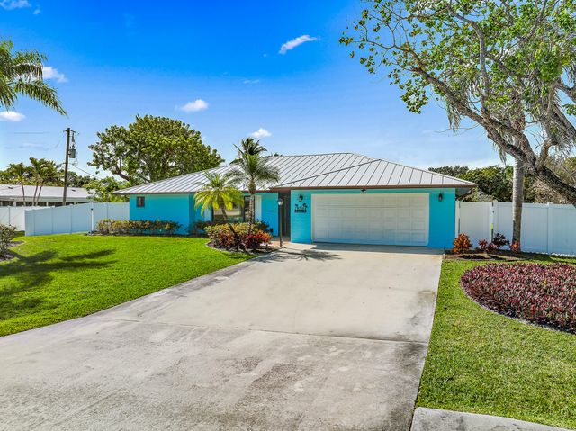 a front view of a house with a garden and yard