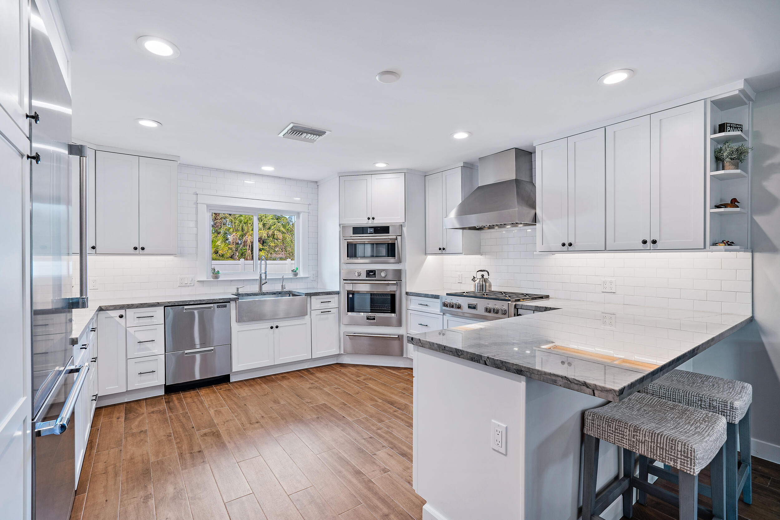 8766 Southeast Longview Drive Hobe Sound, FL 33455 - Photo 4 of 27 a kitchen with white cabinets and appliances