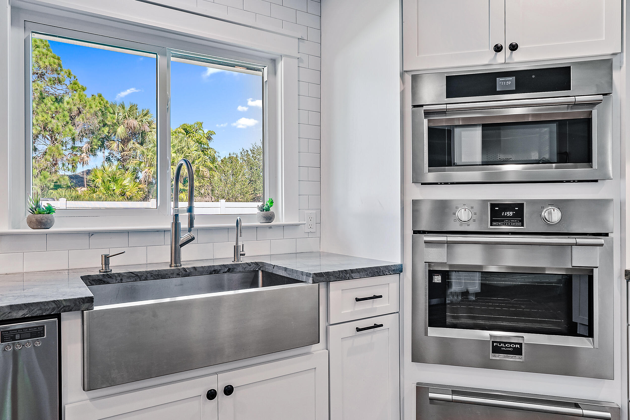 8766 Southeast Longview Drive Hobe Sound, FL 33455 - Photo 5 of 27 a kitchen with granite countertop a stove microwave and sink