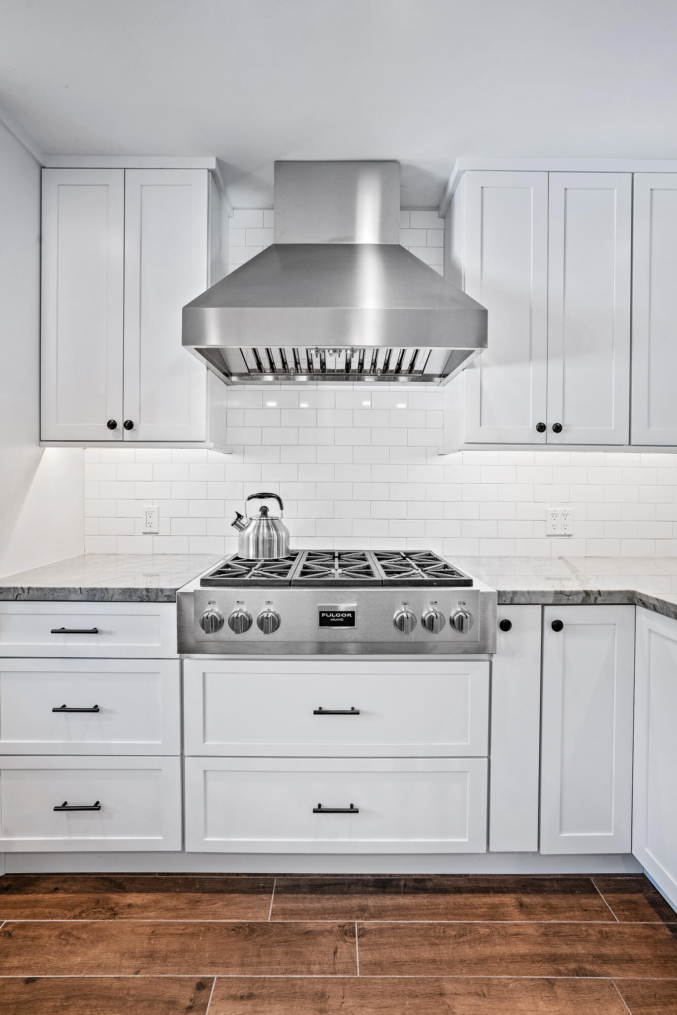 8766 Southeast Longview Drive Hobe Sound, FL 33455 - Photo 6 of 27 a kitchen with white cabinets and a stove
