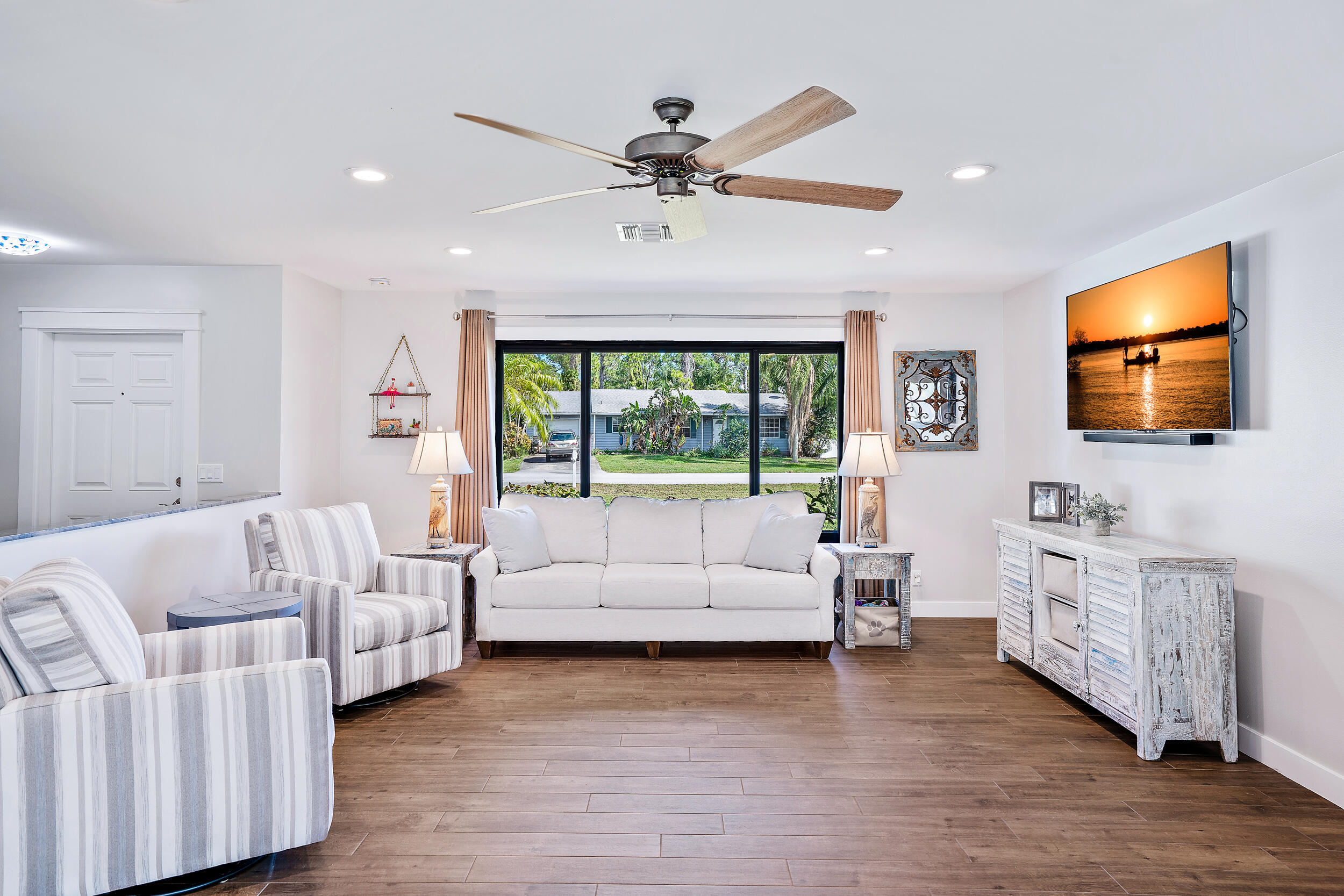 8766 Southeast Longview Drive Hobe Sound, FL 33455 - Photo 8 of 27 a living room with furniture and a flat screen tv